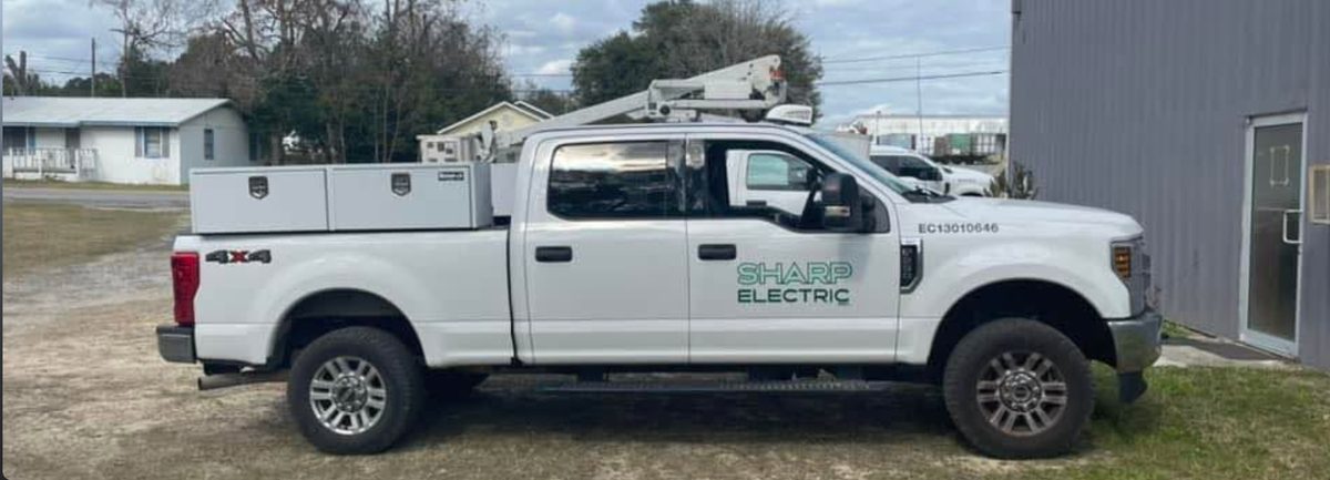 Sharp Electric service truck with utility bucket, parked on a job site in Northeast Florida